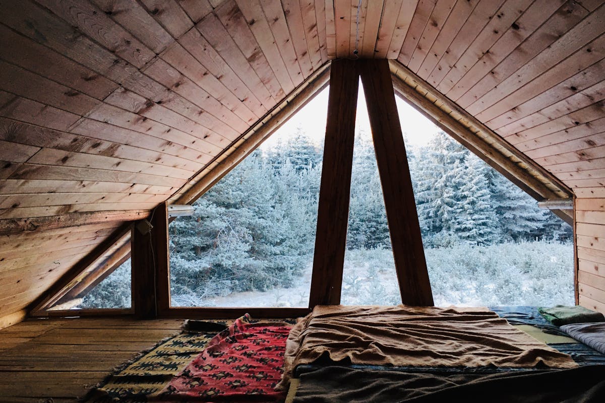 Lit installé sous les combles d'une chambre mansardée de 8 m²
