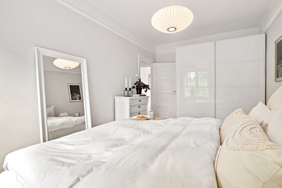 Couleurs claires et grand miroir pour agrandir une chambre de 8 m2