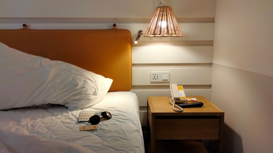 Linge de lit blanc et liseuse de chevet dans une chambre d'hôtel