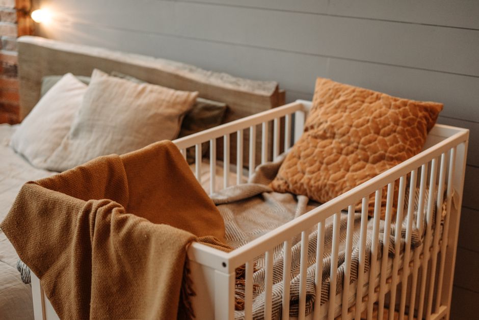 Chambre de bébé en vert kaki avec lit en bois et linge douillet